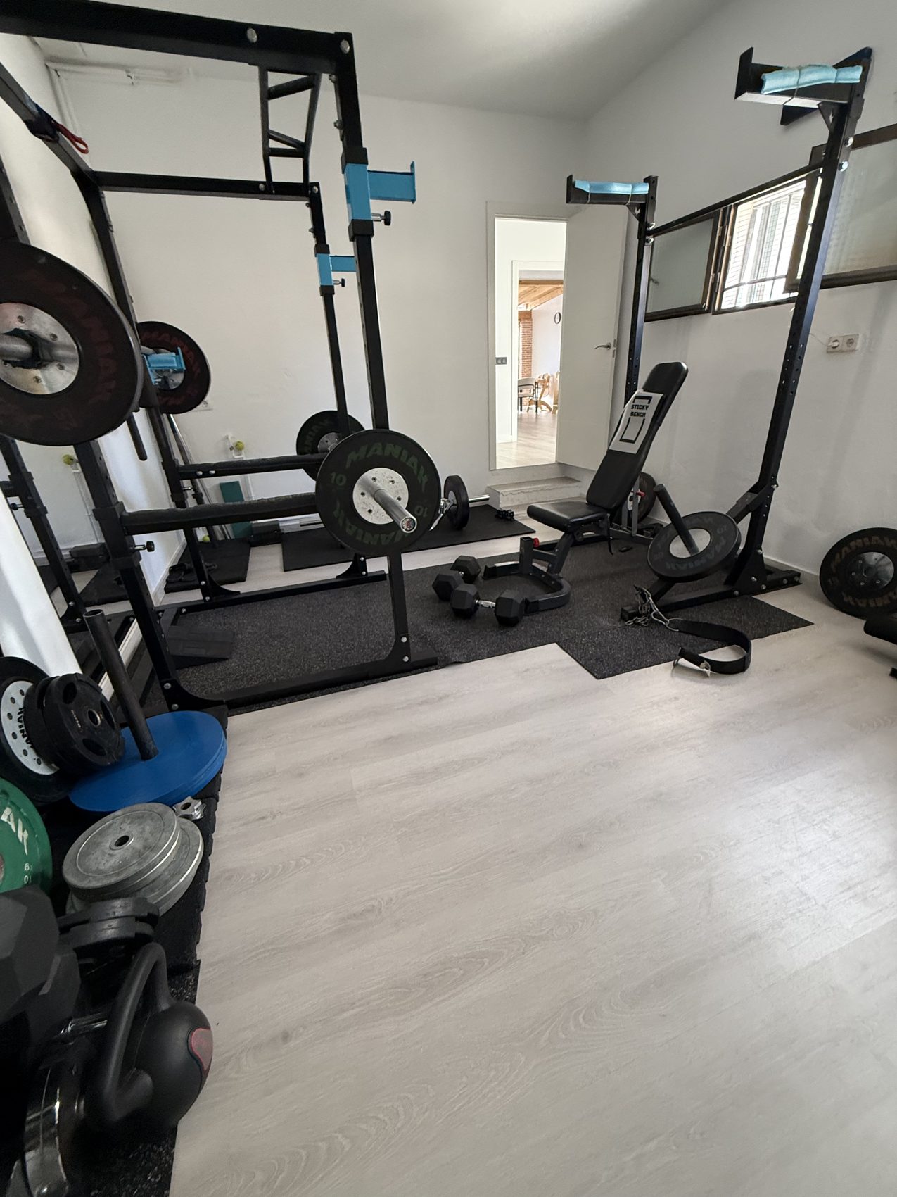 Sala privada con banco y racks de fuerza